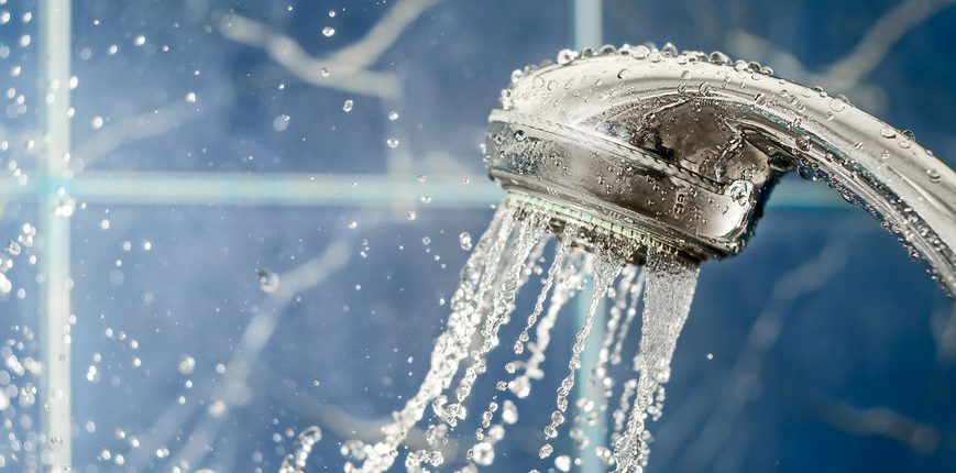 shower head with flow of water spilling out on blue background